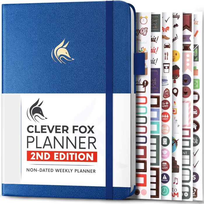 Clever Fox Planner 2nd Edition undated weekly planner in Mystic Blue with sticker sheets fanned beside it