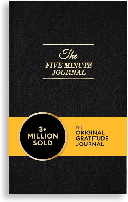 The Five Minute Journal by Intelligent Change with a black linen cover