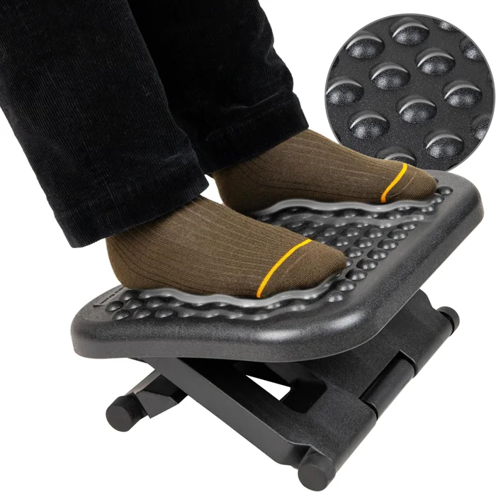 Mind Reader adjustable under-desk footrest in black plastic with a textured top, feet in socks resting on it