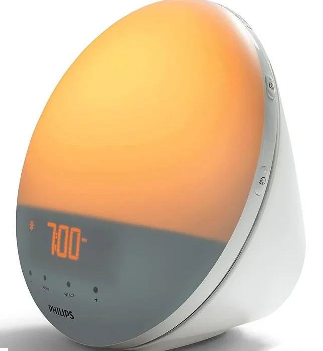 Philips SmartSleep Wake-up Light HF3520 lamp glowing orange with its clock display showing 7:00